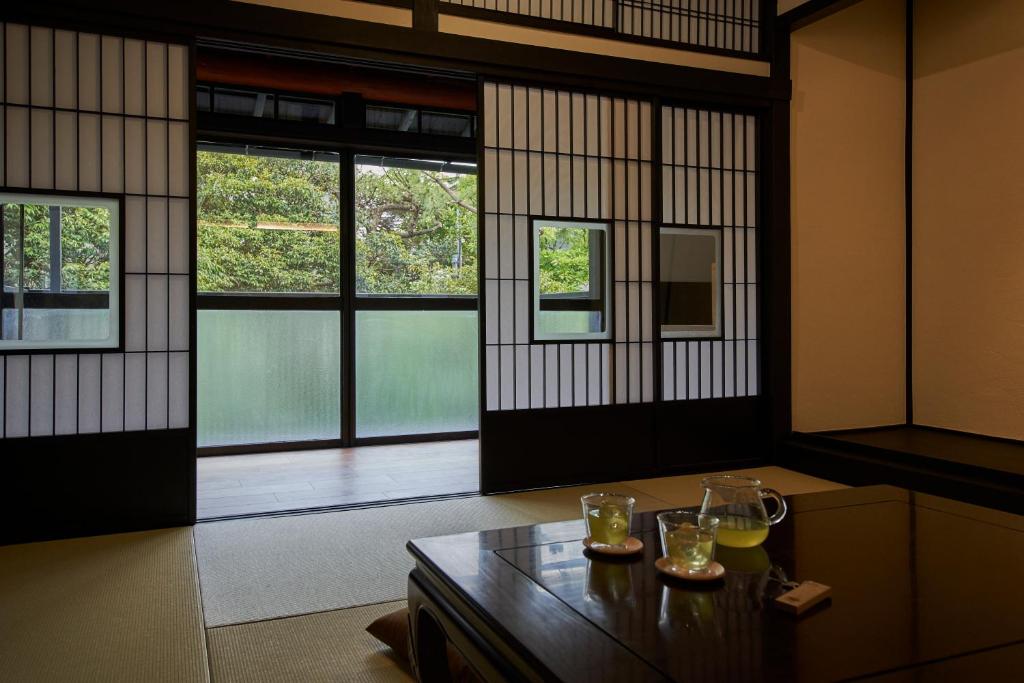 une pièce avec deux verres sur une table avec des fenêtres dans l'établissement AKAMA Kamakura, à Kamakura
