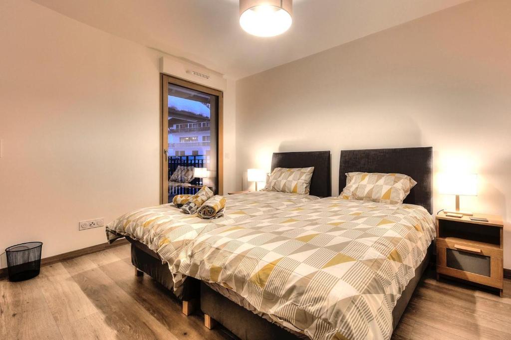 une chambre avec un grand lit et une fenêtre dans l'établissement Apartment Gallery Mont Blanc Saint-Gervais-Les-Bains, à Saint-Gervais-les-Bains