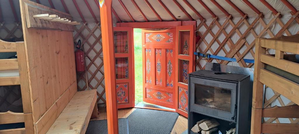 Cette petite chambre comprend une cuisinière et une porte. dans l'établissement La Petite Echelle, à Rochejean