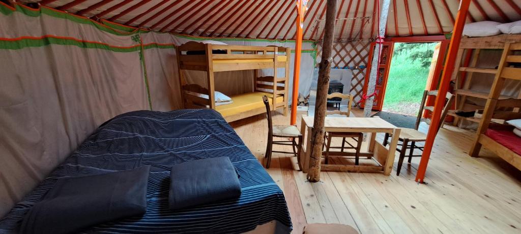 - une chambre dans une tente avec un lit et un bureau dans l'établissement La Petite Echelle, à Rochejean 37 autres photos