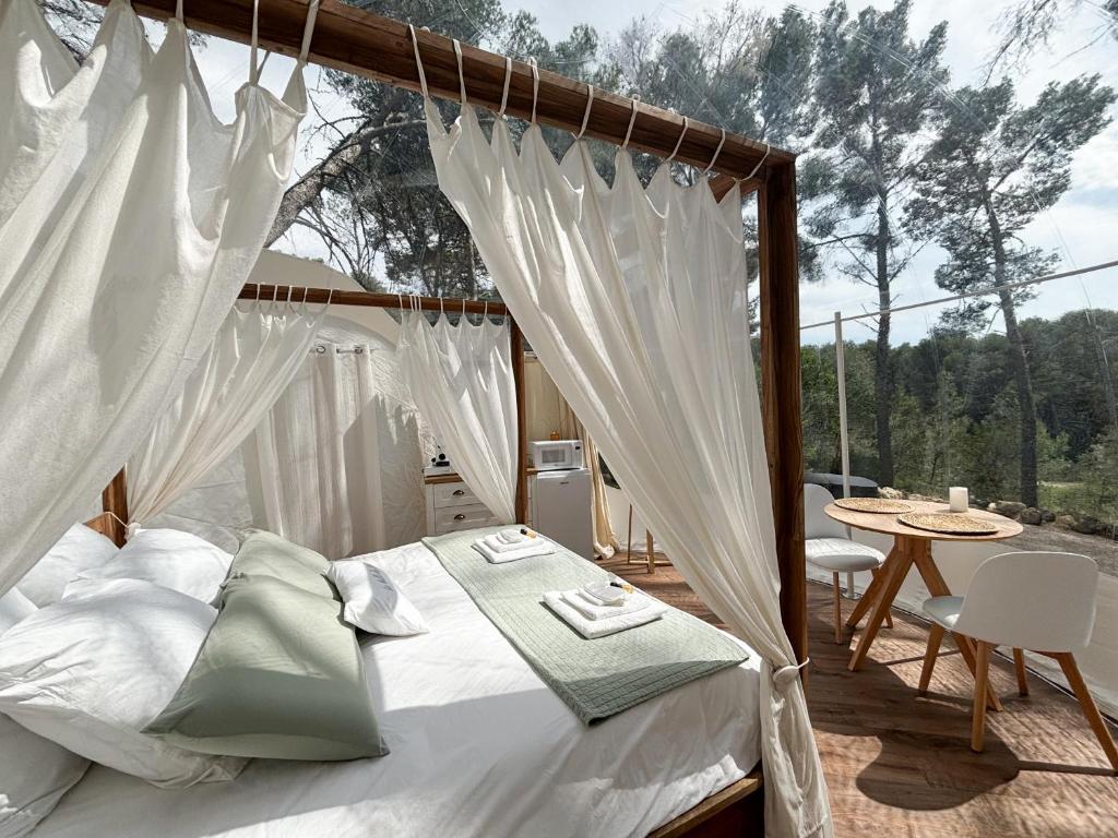 - une chambre avec un lit et une terrasse avec une table dans l'établissement La Bulle des Pins, à Istres