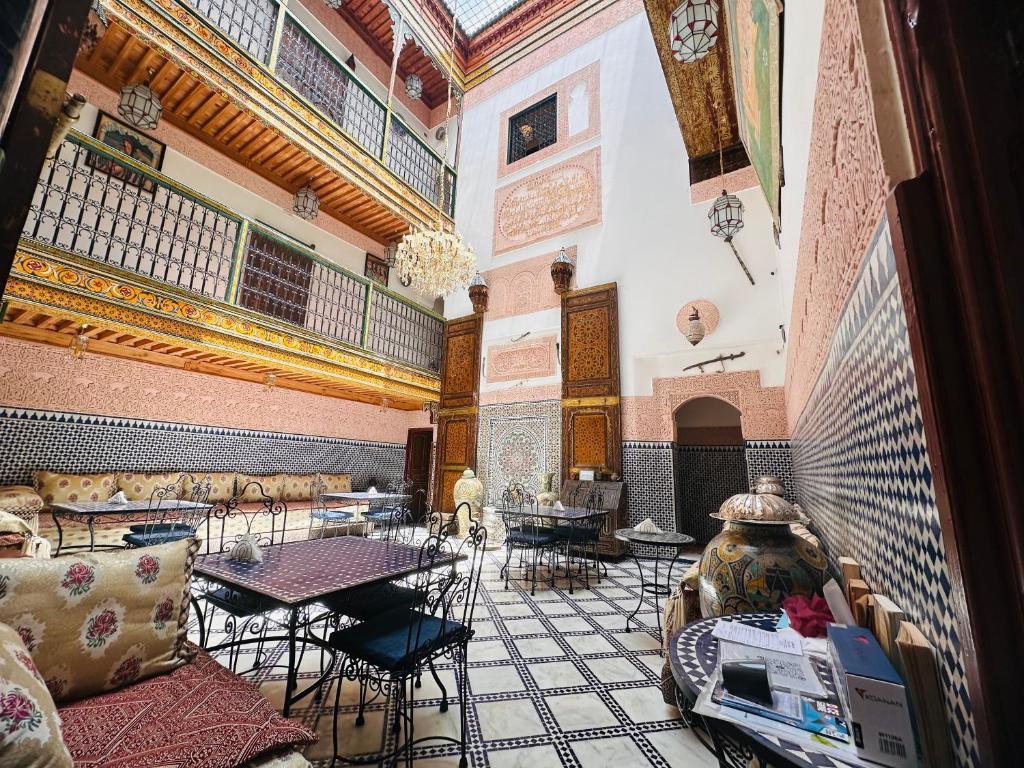 une pièce avec des tables et des chaises dans un bâtiment dans l'établissement Riad Dar Tahri & SPA, à Fès
