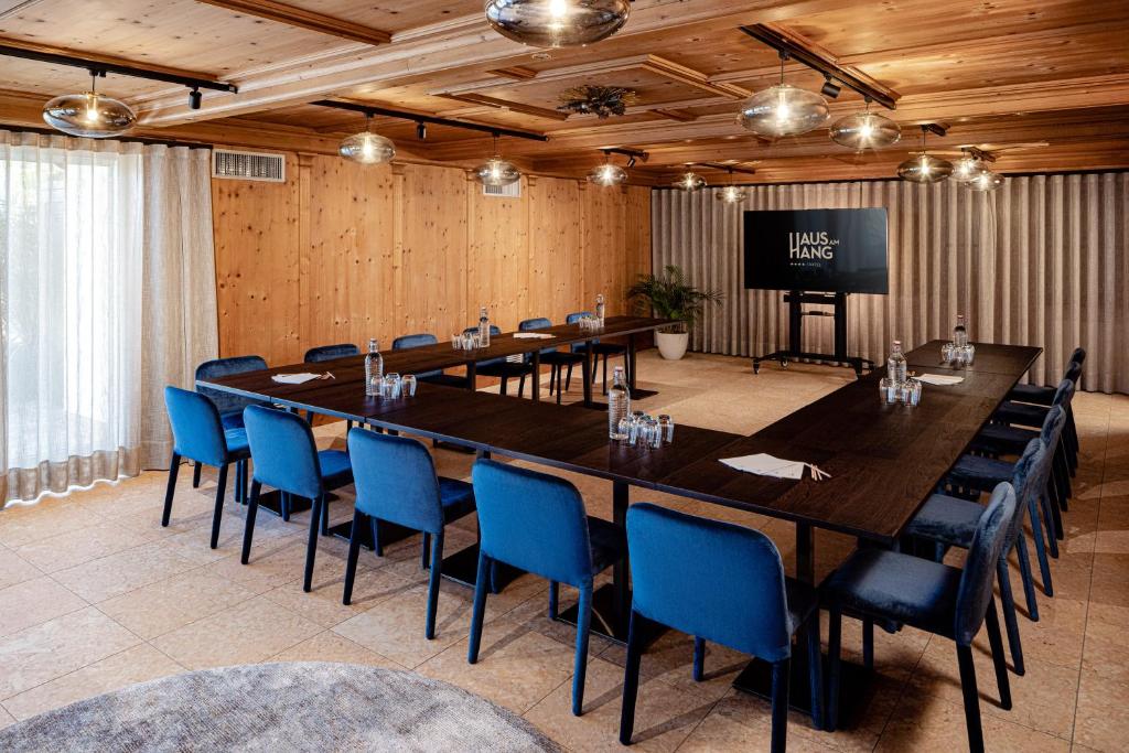 une grande salle de conférence avec une grande table et des chaises bleues dans l'établissement Hotel Haus am Hang, à Caldaro 48 autres photos
