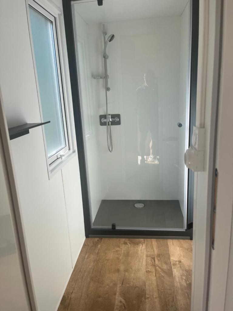 une salle de bain avec une douche avec une porte vitrée dans l'établissement LE PIPA, à Quend