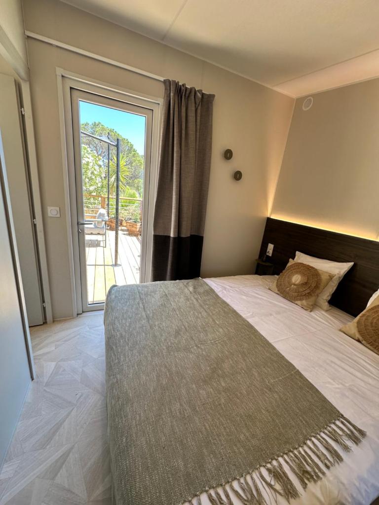 une chambre avec un grand lit et une grande fenêtre dans l'établissement Voltaire, à Saint-Raphaël 27 autres photos