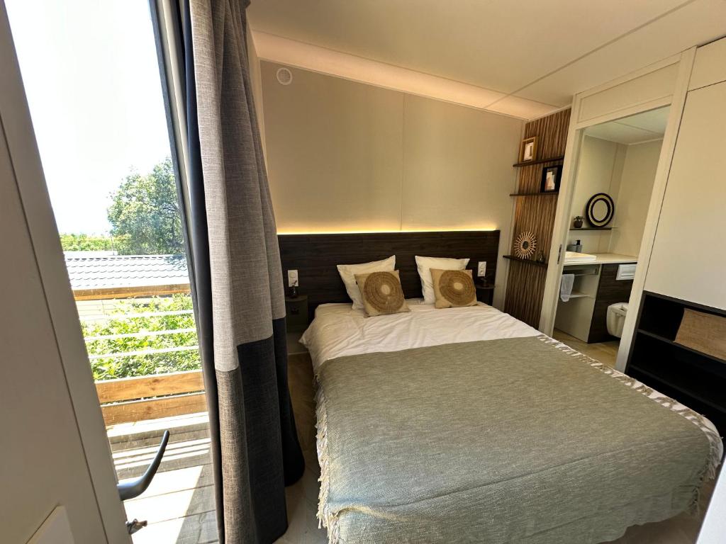 une chambre avec un lit et un balcon dans l'établissement Voltaire, à Saint-Raphaël