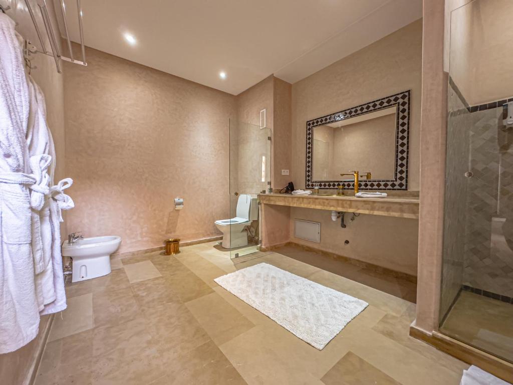 une salle de bain avec toilettes, lavabo et miroir dans l'établissement Riad Kenza, à Marrakech