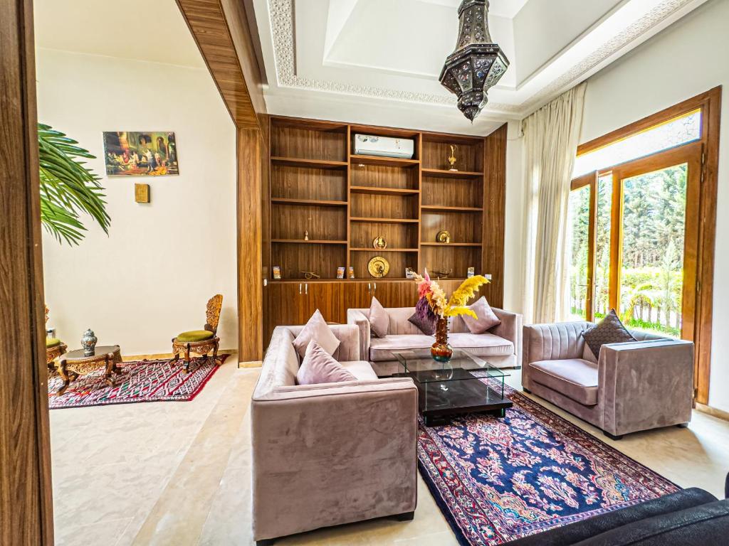 - un salon avec deux canapés et une étagère à livres dans l'établissement Riad Kenza, à Marrakech