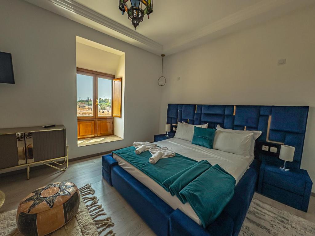 une chambre avec un grand lit avec une tête de lit bleue dans l'établissement Riad Kenza, à Marrakech 37 autres photos