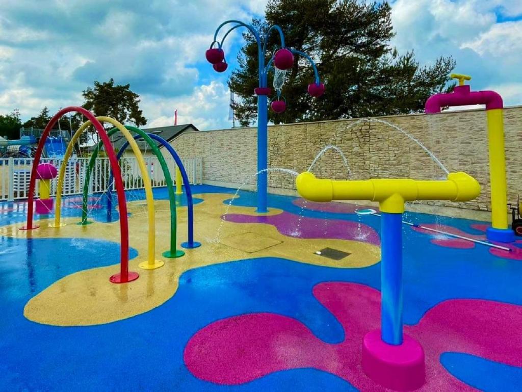 un parc aquatique coloré avec toboggans et manèges dans l'établissement MHVACANCES 2 LOUENT PLUSIEURS MOBILHOMES DANS CAMPING 4 ETOILES PROCHE CHATEAUX et ZOO BEAUVAL, à Onzain