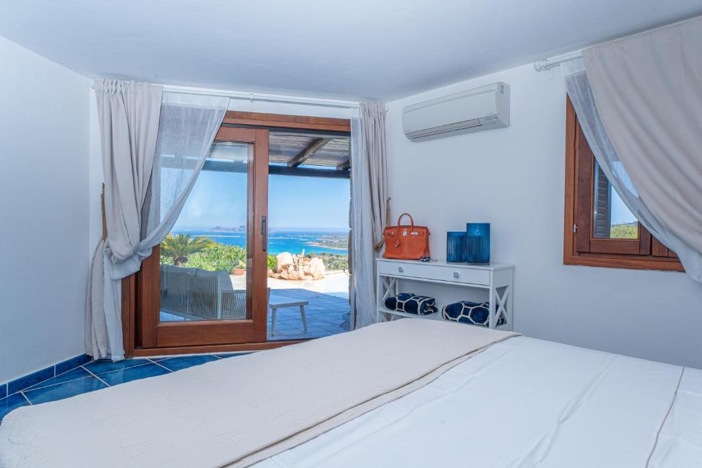 une chambre avec un lit et une vue sur l'océan dans l'établissement Villa Graya, à Porto Istana