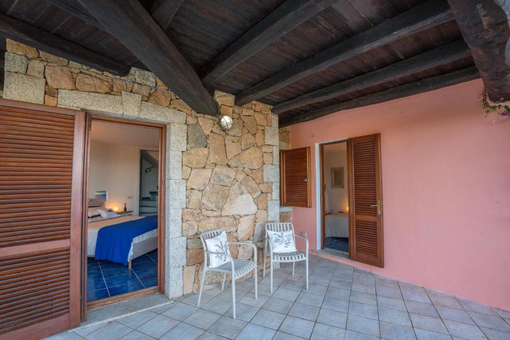 Cette chambre dispose d'une terrasse avec 2 chaises et d'un lit. dans l'établissement Villa Graya, à Porto Istana