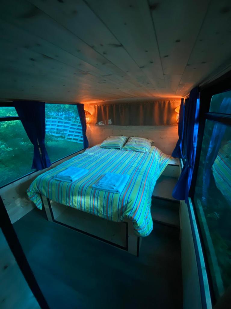 un lit à l'arrière d'un bus avec des lumières dans l'établissement Woody Wood Bus, à Vergeroux