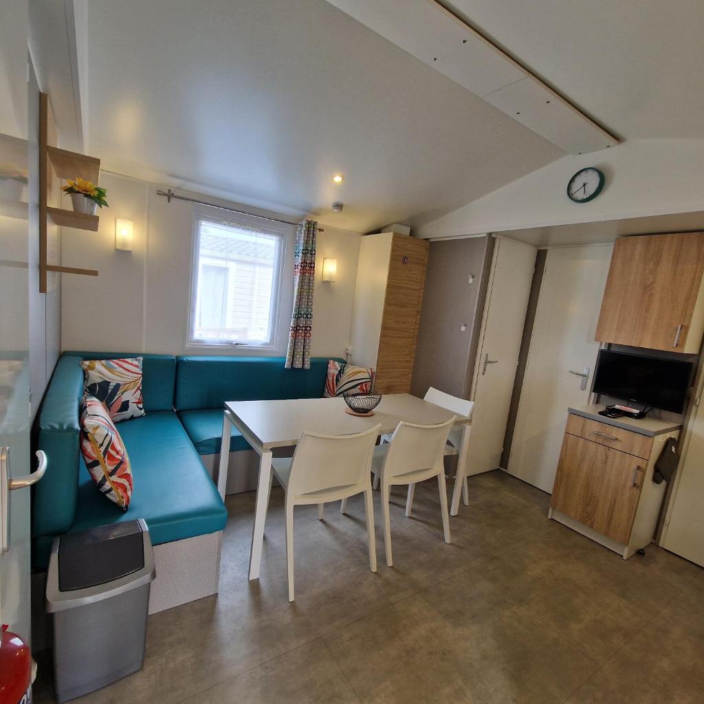 un salon avec un canapé, une table et des chaises dans l'établissement MH2-CONFORT- 3CH - 6 pl - TV- LAVE VAISSELLE - WI-FI - "Draps fournis-Lits faits à votre arrivée" en option -- "Fun-Pass" OFFERT sous conditions !!, à Pont-Aven