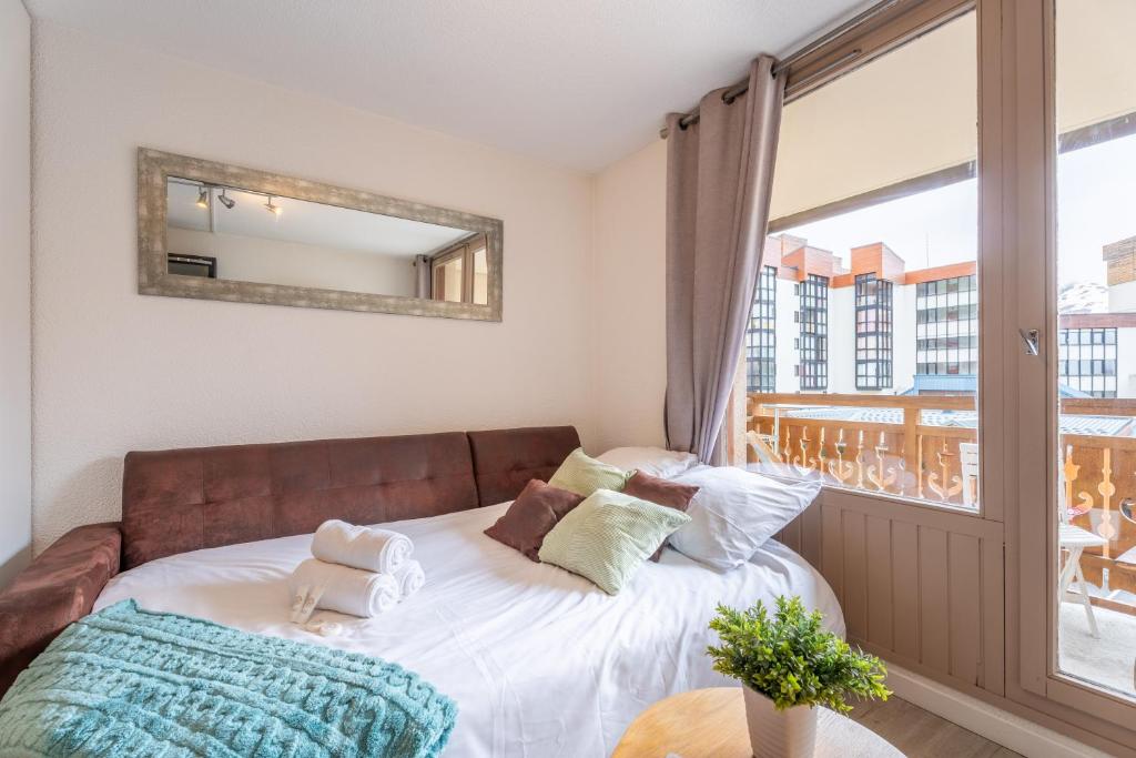 une chambre avec un lit avec un miroir et une fenêtre dans l'établissement Ski In-Out - Heart of Val Thorens Beautiful View, WiFi 108, à Val Thorens
