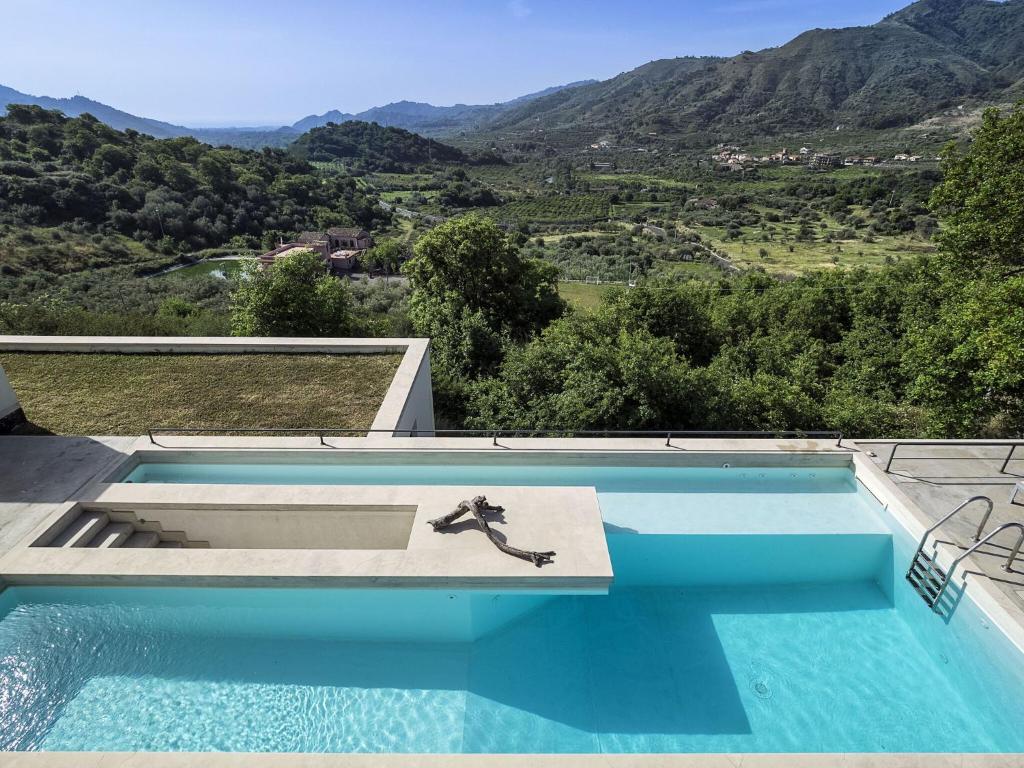 une piscine avec vue sur une montagne dans l'établissement Villa Alcantara, à Gaggi