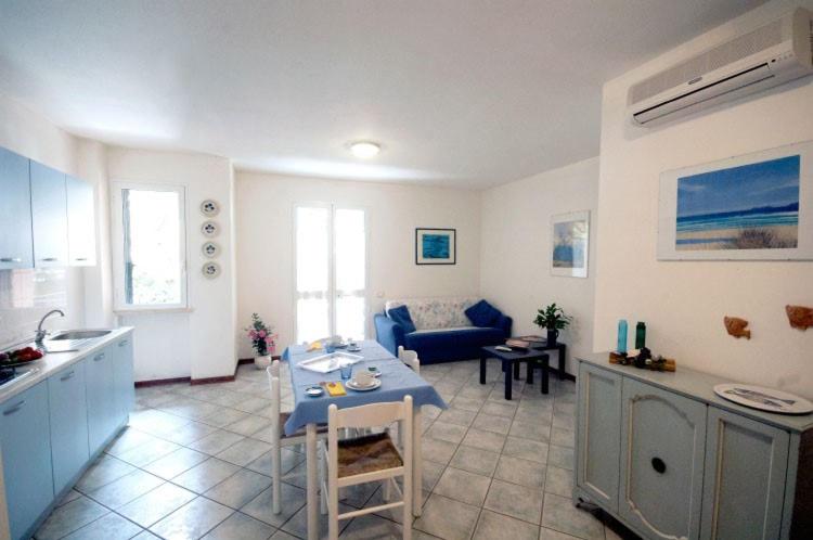 une cuisine et un salon avec une table et un canapé dans l'établissement Residence Loggetta Margherita, à San Vincenzo 9 autres photos