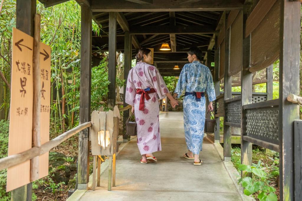 deux personnes en kimono marchant dans une allée dans l'établissement Setsugetsuka, à Hakone