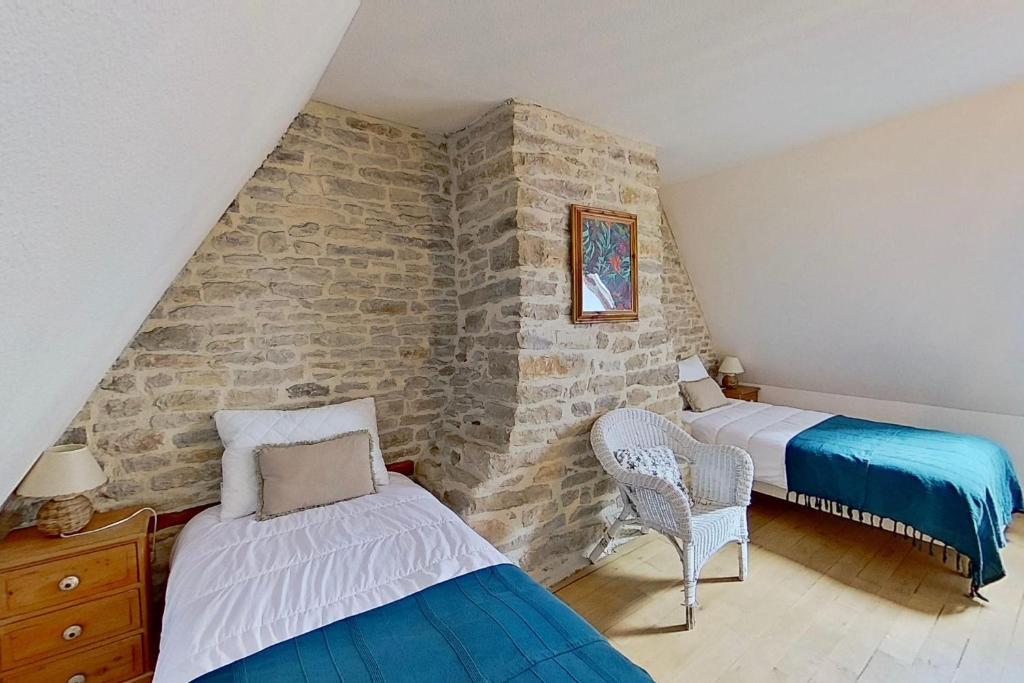 une chambre avec deux lits et un mur en pierre dans l'établissement Domaine de Montanty, à Gramat 37 autres photos