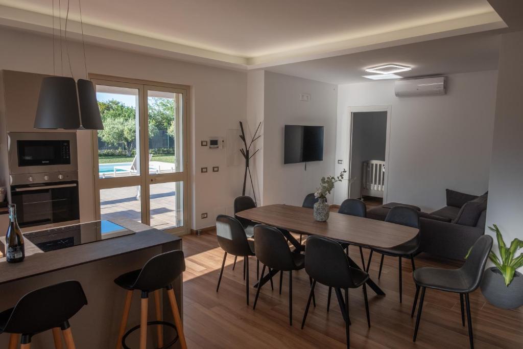 une cuisine et un salon avec une table et des chaises dans l'établissement Villa Flara Relais, à Calatabiano