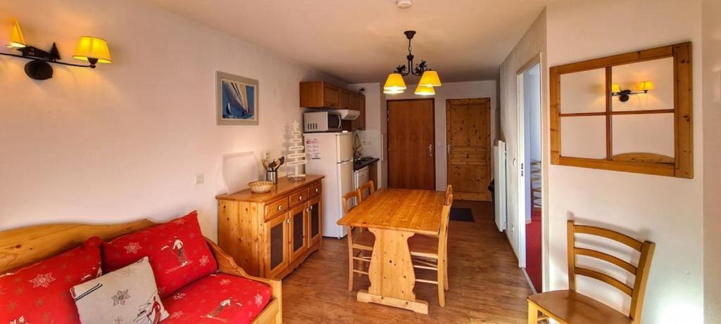 un salon avec un canapé rouge et une table dans l'établissement Appart chaleureux au pied des pistes avec piscine, à Orcières