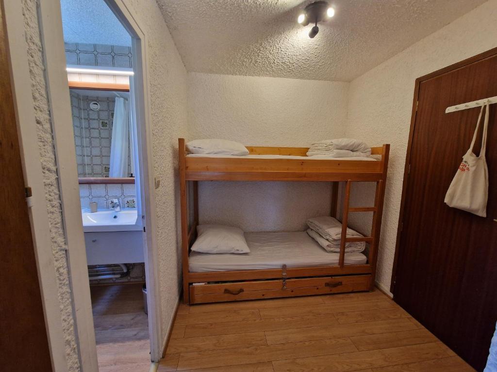Cette petite chambre comprend des lits superposés et un lavabo. dans l'établissement Les Brimbelles 27 studio au pied du télémix de Belle Étoile, à Les Deux Alpes