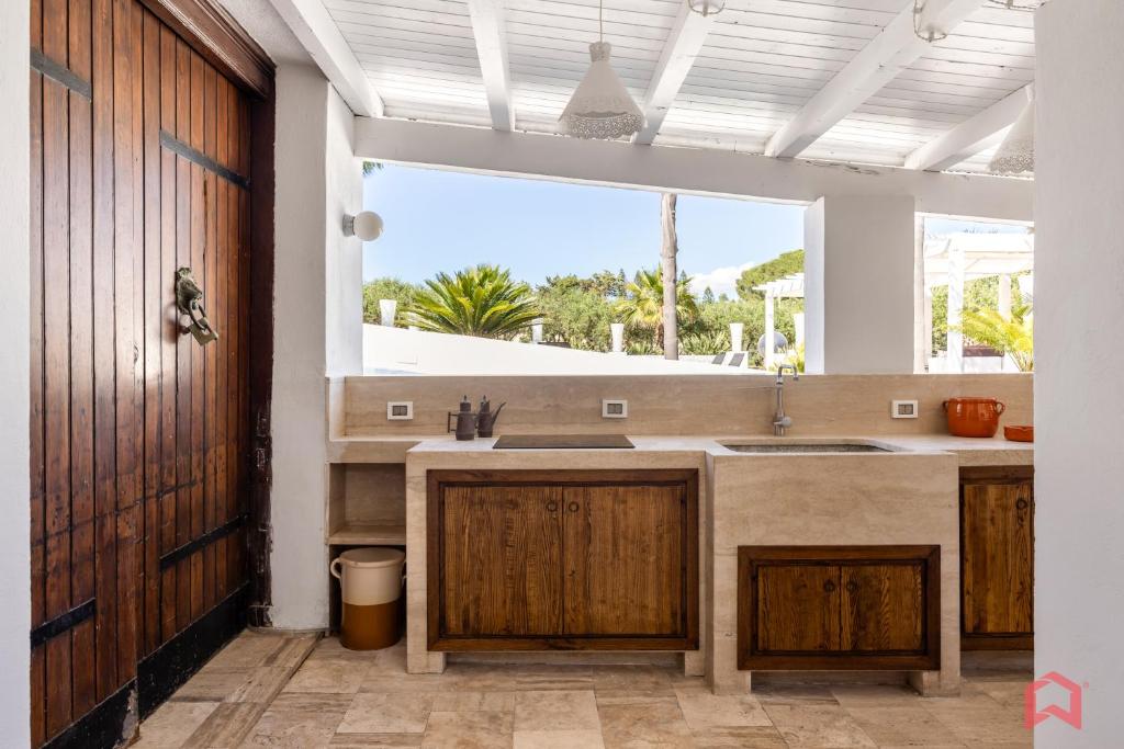 une cuisine avec un évier et une grande fenêtre dans l'établissement Amazing Villa with pool & Jacuzzi, à Balestrate