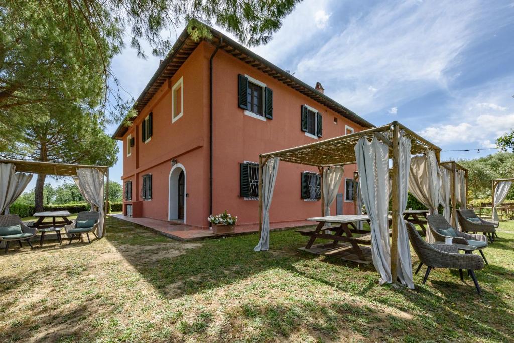 une maison avec une table de pique-nique et des chaises dans la cour dans l'établissement Villa Boscone by Mmega, à Querce