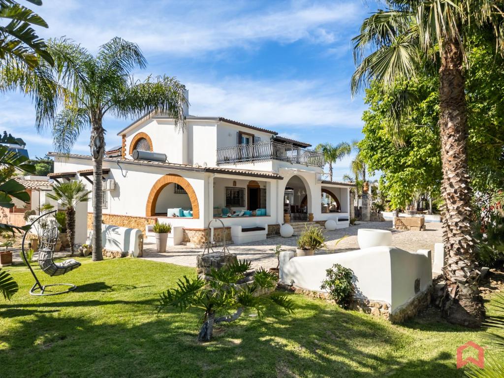 - une vue sur l'extérieur d'une maison avec des palmiers dans l'établissement Amazing Villa with pool & Jacuzzi, à Balestrate