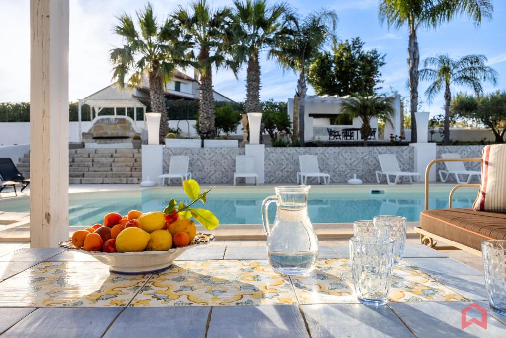 - un bol de fruits sur une table à côté de la piscine dans l'établissement Amazing Villa with pool & Jacuzzi, à Balestrate