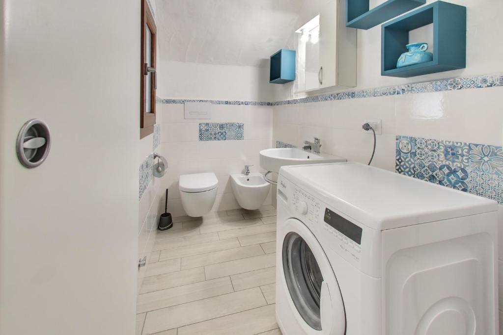 La salle de bains est pourvue d'un lave-linge, de toilettes et d'un lavabo. dans l'établissement Porto Ottiolu Resort, à Porto Ottiolu