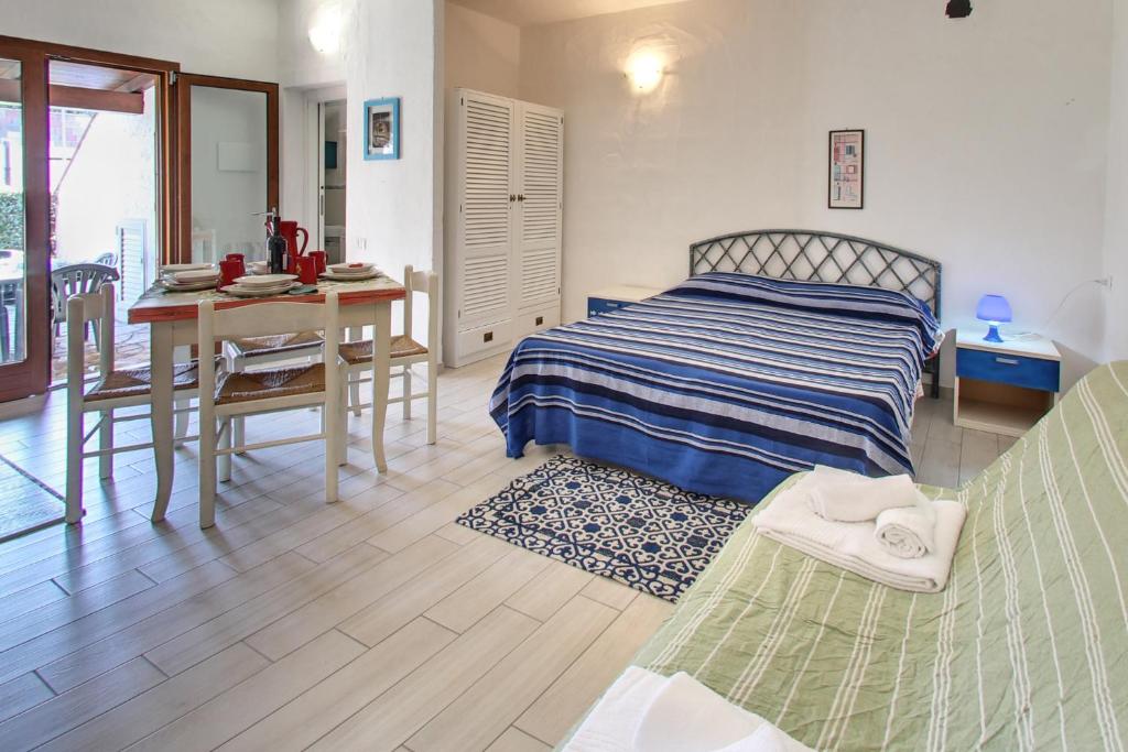 une chambre avec un lit, une table et un bureau dans l'établissement Porto Ottiolu Resort, à Porto Ottiolu