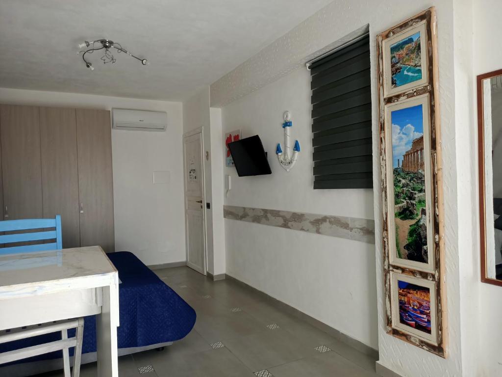 Cette chambre comprend une table et une chaise bleue. dans l'établissement RESINDENZE Donna Sabella, à Santa Flavia