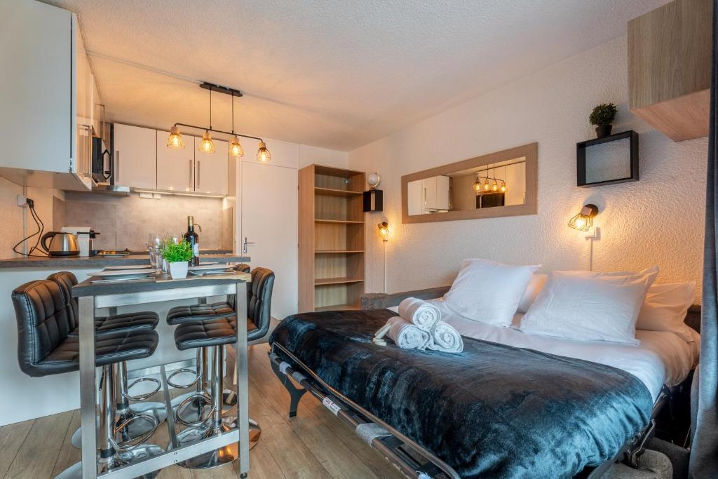une chambre avec un lit et une table et une cuisine dans l'établissement Ski In-Out - Heart of Val Thorens Convenient Flat, WiFi 92, à Val Thorens 15 autres photos