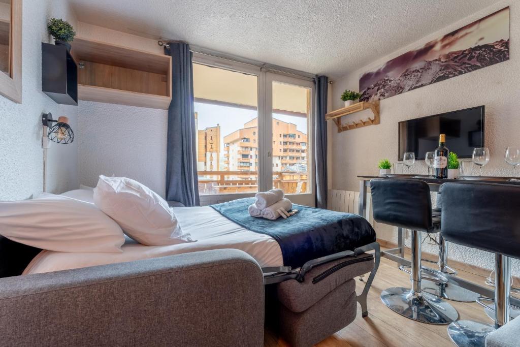 une chambre d'hôtel avec un lit et un bar avec une fenêtre dans l'établissement Ski In-Out - Heart of Val Thorens Convenient Flat, WiFi 92, à Val Thorens