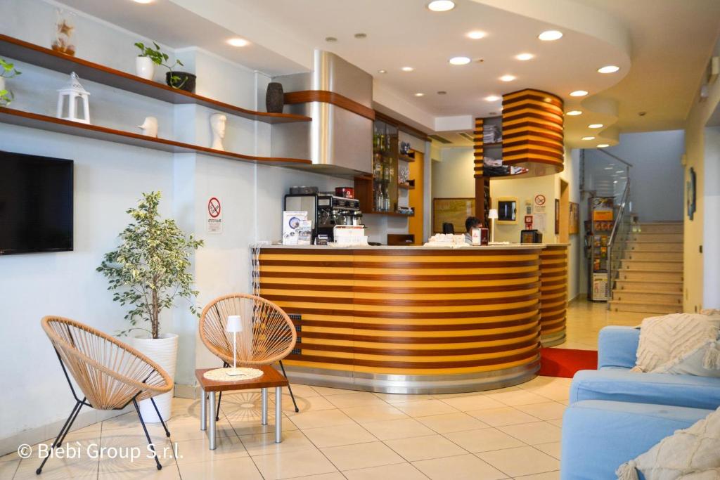un hall d'entrée avec un bar avec des chaises et un canapé dans l'établissement Hotel Giorg - WaterPark Free Entrance, à Rimini