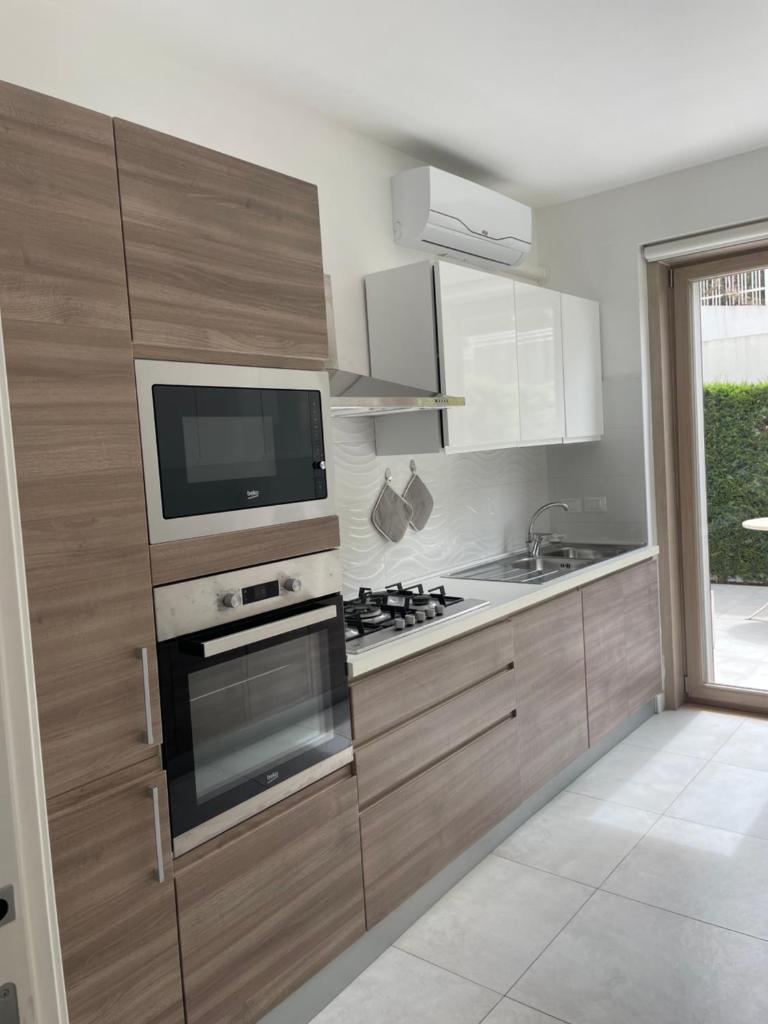 Il comprend une cuisine équipée d'une cuisinière et une télévision murale. dans l'établissement Luxury villa Blue&Blanc piscina a sfioro isola, à Diamante