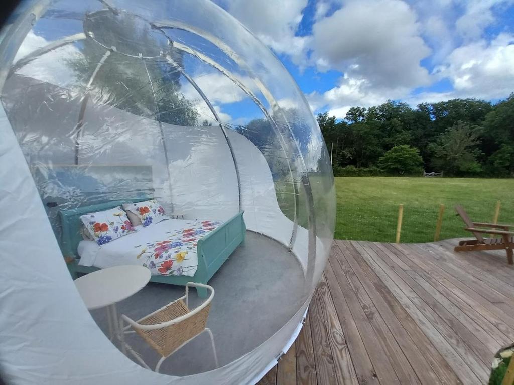 un igloo avec un lit à l'intérieur sur une terrasse dans l'établissement La Bulle des alpagas, à Herry 4 autres photos