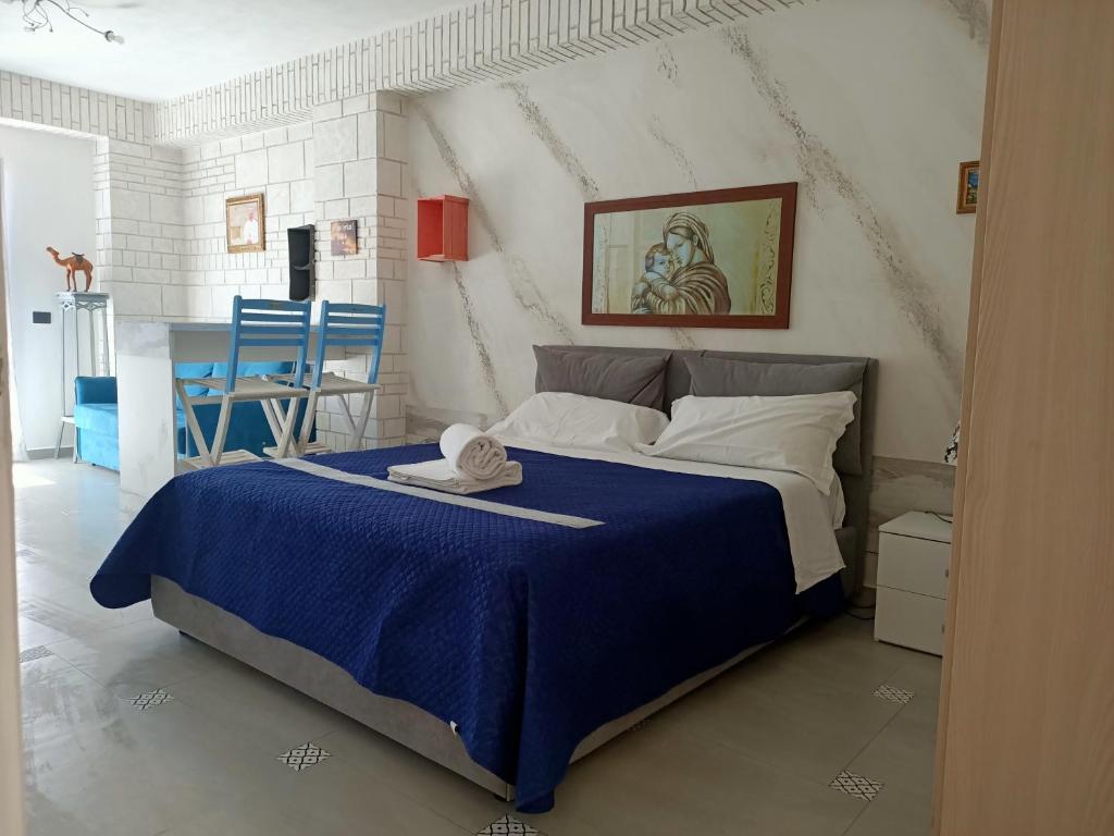 - une chambre avec un lit doté d'une couverture bleue et de chaises dans l'établissement RESINDENZE Donna Sabella, à Santa Flavia