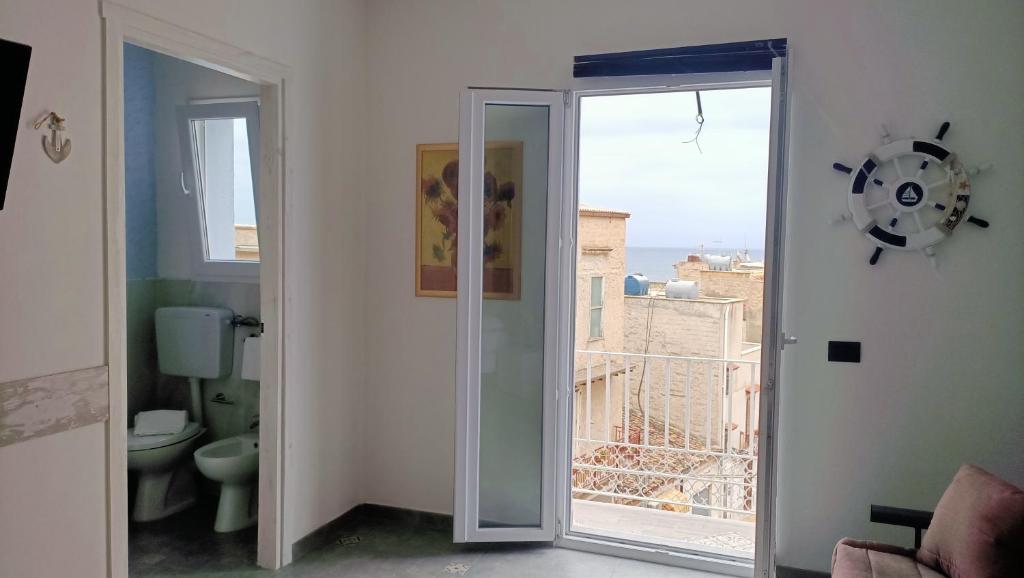 La salle de bains est pourvue de toilettes et d'une porte coulissante en verre. dans l'établissement RESINDENZE Donna Sabella, à Santa Flavia