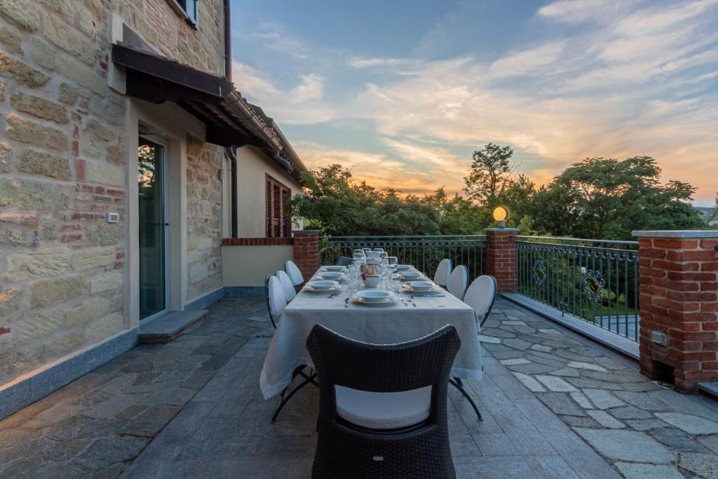 une table et des chaises assises sur une terrasse dans l'établissement Villa Ca' Vecchia, à Olivola