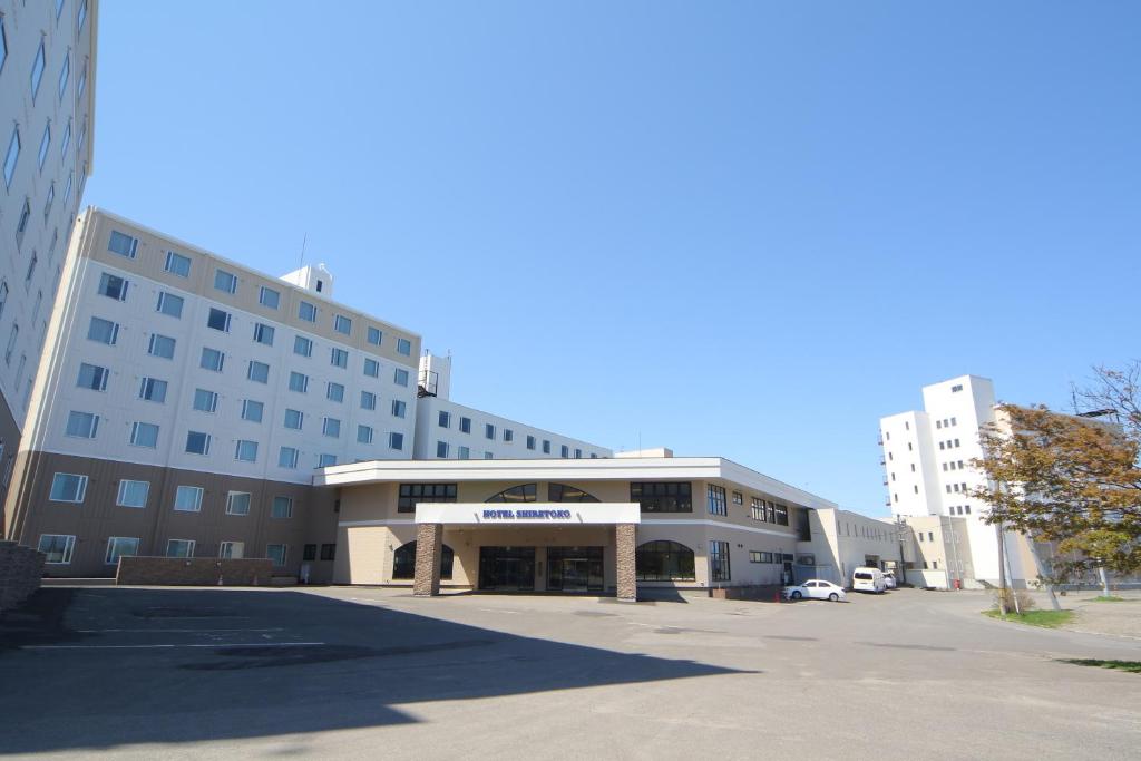 un grand bâtiment avec un parking devant dans l'établissement Hotel Shiretoko, à Shari