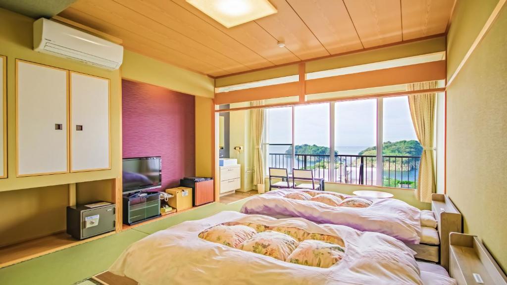 une chambre avec deux lits et une grande fenêtre dans l'établissement Futagojimasou, à Wakayama 40 autres photos