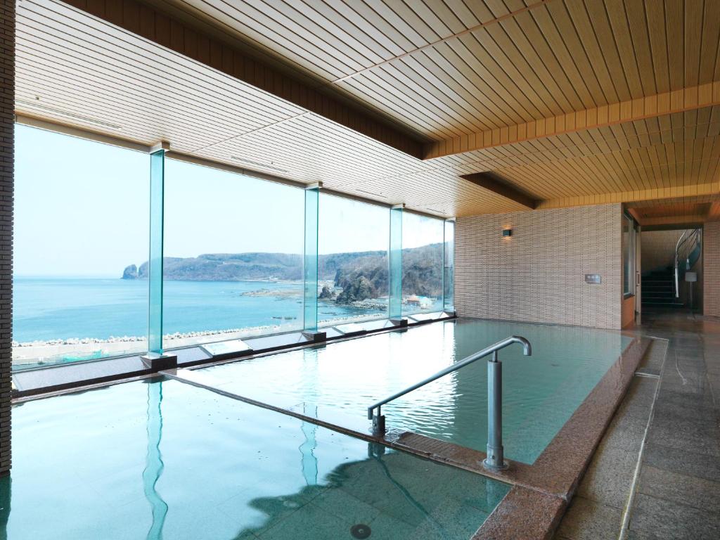 une grande piscine avec vue sur l'océan dans l'établissement Kitakobushi Shiretoko Hotel & Resort, à Shari