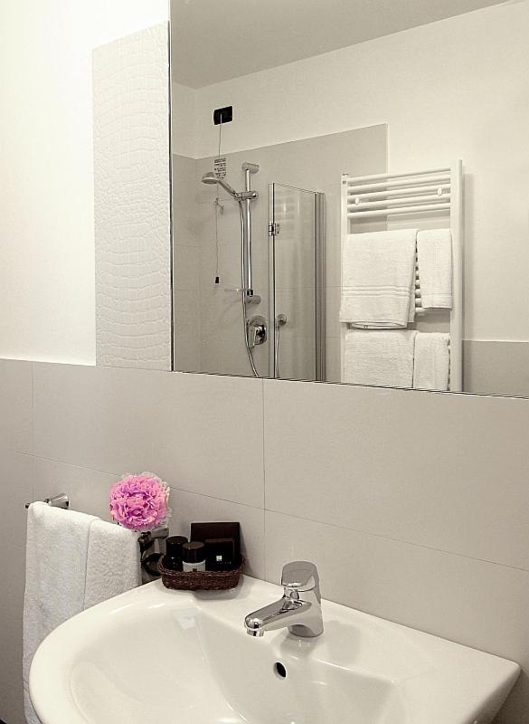 une salle de bain blanche avec un lavabo et un miroir dans l'établissement Hotel Villa Pannonia, sur le Lido de Venise