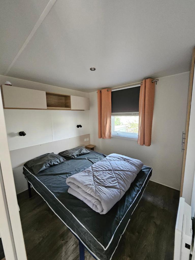 un lit dans une petite pièce avec une fenêtre dans l'établissement Mobilhome L'Estérel du Montourey, à Fréjus