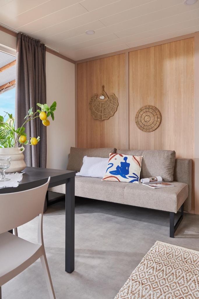 un salon avec un lit et une table dans l'établissement Camping U Pirellu, à Porto-Vecchio