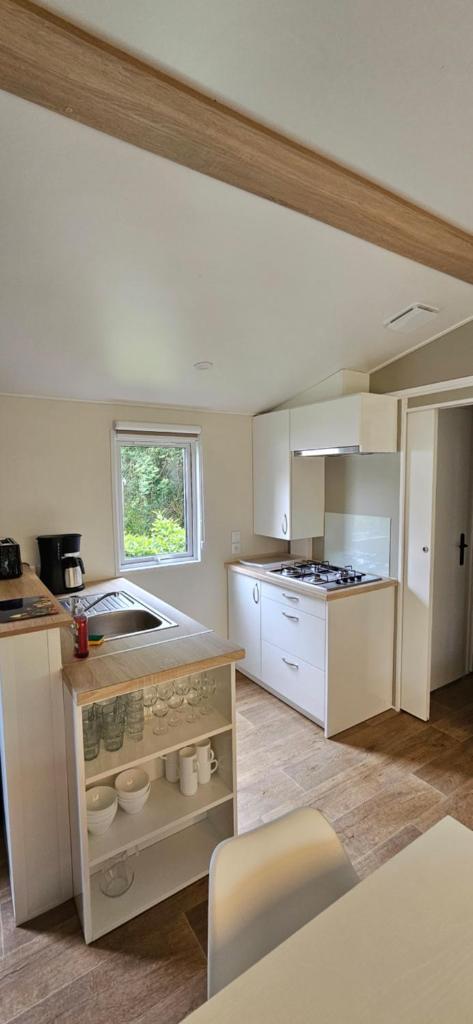 La cuisine est équipée de placards blancs, d'un évier et d'un comptoir. dans l'établissement Mobil-Home 3 chambres - Camping Les Ollivaud, à La Baule