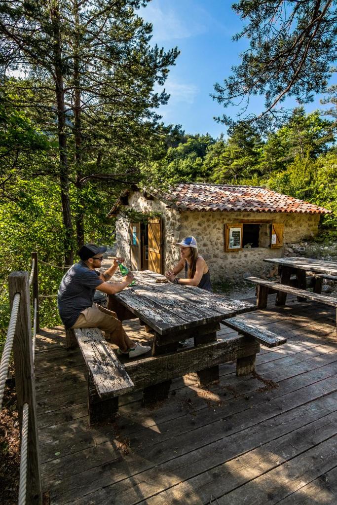 Un groupe de personnes assis à une table de pique-nique dans l'établissement Adventure Forest, à Castellane
