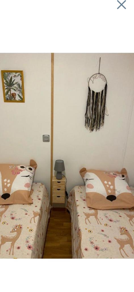 une chambre avec deux lits et un lustre dans l'établissement L éden, à Hyères